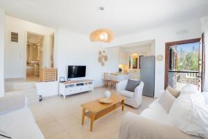 a living room with a white couch and a table at Almyra Villas in Xerokampos