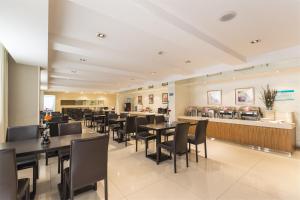 a restaurant with black tables and chairs and a counter at Jinjiang Inn Linyi Luozhuang in Linyi