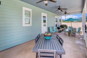 a picnic table on a porch with a ceiling fan at 5 Bed, 5 Bath Beach Home/Only a 3 Minute Walk To The Beach! SLEEPS 12 in Sunnyside