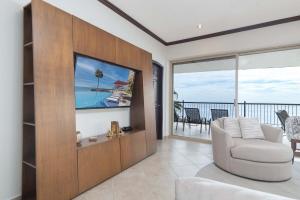 a living room with a white chair and a television at Sonoran Sky in Puerto Peñasco
