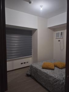 a bedroom with a bed and a window with blinds at Robinsons Galleria Tower 2 - Nice Place in Cebu City