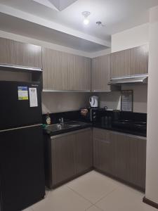 a kitchen with a black refrigerator and a sink at Robinsons Galleria Tower 2 - Nice Place in Cebu City