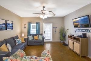 a living room with a couch and a tv at Palm Bay 305 in Corpus Christi