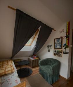 a living room with a window and a couch and a chair at Ozierański Raj "Pod rzeźbami" in Krynki +66 photos
