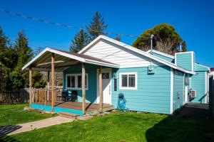a blue house with a porch and a deck at Bungalow by the Bay in Netarts