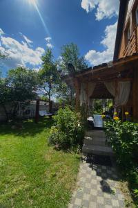 a pergola on the side of a house at Ozierański Raj "Pod rzeźbami" in Krynki