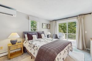 Un dormitorio con una cama y una ventana grande. en Jack's Dacha, en Dennis