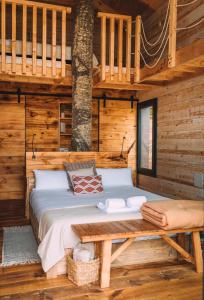 a bed in a log cabin with a wooden floor at Cabanyes entre Valls in Vall de Bianya