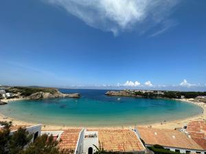 a view of a beach with blue water at Costa Arenal 111 by SOM Menorca in Arenal d'en Castell