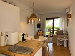 a kitchen and living room with a table with a microwave at Costa Arenal 111 by SOM Menorca in Arenal d'en Castell