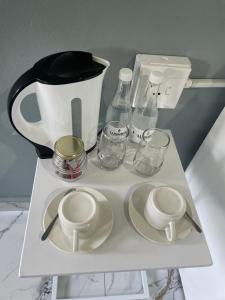 a white shelf with a coffee pot and glasses on it at Lupulo luxury boutique in Thohoyandou