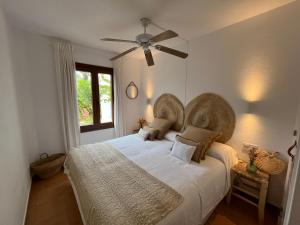 a bedroom with a large bed with a ceiling fan at Costa Arenal 111 by SOM Menorca in Arenal d'en Castell +15 photos