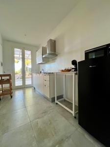 a kitchen with a white counter and a table at Arneo Rooms in Torre Lapillo