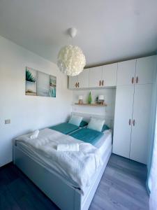 a bedroom with a bed and a chandelier at Garden Home Apartman in Balatonföldvár