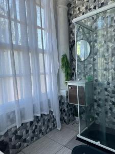 a bathroom with a shower with curtains and a mirror at Hotel Cidade Imperial in Petrópolis +50 photos