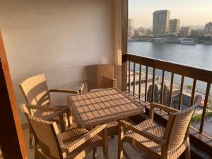 a table and chairs on a balcony with a view of the water at Nile sky hotel and suites in Cairo