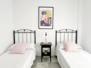 two beds sitting next to each other in a room at Apartamento comedia in Sanlúcar de Barrameda