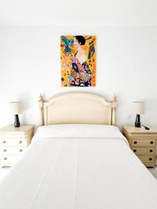 a bedroom with a white bed with a painting on the wall at Apartamento comedia in Sanlúcar de Barrameda