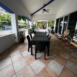 a patio with a black table and chairs on a house at Luxury Beachfront House with Pool in Palo Grande