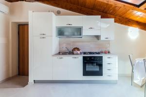 Una cocina con gabinetes blancos y un horno de estufa. en Casa Vacanza Diadema, en Matera