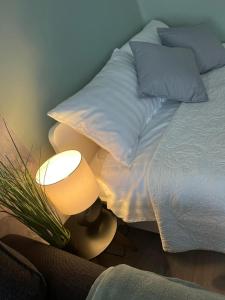 a bedroom with a bed with pillows and a lamp at Apartament Piaskowa Mountain & Coffee in Wałbrzych