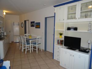 eine Küche und ein Esszimmer mit einem Tisch und einem TV in der Unterkunft Apartmentanlage "Am Salzhaff" in Rerik