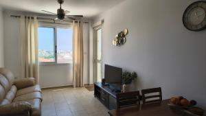 a living room with a couch and a clock on the wall at Ferienwohnung mit Meerblick in Khlorakas