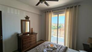 a bedroom with a bed and a mirror and a window at Ferienwohnung mit Meerblick in Khlorakas +20 photos