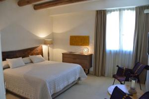 a bedroom with a bed and a desk and a window at Le Scuderie - Castello Monaci in Salice Salentino +65 photos