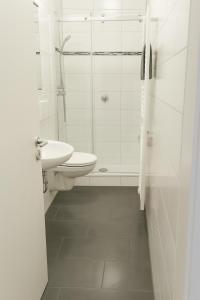 a white bathroom with a toilet and a sink at RuhrpottImmo - Zentrale Wohnung in Iserlohn - bis zu 7 Pers in Iserlohn