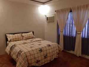 a bedroom with a bed and a window with curtains at Fuji in Angeles