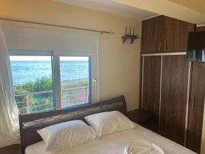 a bedroom with a bed and a large window at Sunnyhomes Vrachos in Vráchos