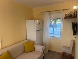 a living room with a couch and a white refrigerator at Sunnyhomes Vrachos in Vráchos