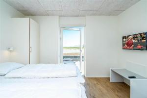 Un dormitorio blanco con una cama y un escritorio. en 903-Hvide-Sande-Langsand-94, en Hvide Sande