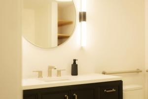 une salle de bains avec un lavabo et un miroir dans l'établissement Above The Roots - Elegant and Bright Studio Stay, à Washington