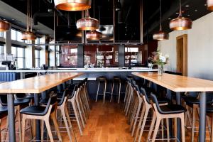 un grand bar avec des tables et des chaises en bois dans l'établissement Above The Roots - Elegant and Bright Studio Stay, à Washington