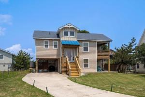 a house with a porch and a garage at Work Trip in Kill Devil Hills