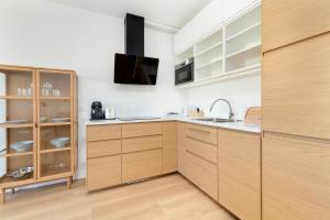 a kitchen with wooden cabinets and a sink at Dorsza Green View Pogórze by Solarento in Pogórze