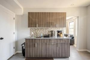 a kitchen with wooden cabinets and a living room at Modern 3-Bdrm Apt in Black Rock in Bridgeport