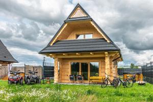 a small wooden house with a gambrel roof at Góralskie Domki u Topora in Czarny Dunajec