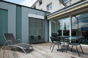 a patio with a table and chairs on a deck at Hotel City in Villach