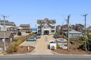 a large house with cars parked in a parking lot at Y-Worry in Kill Devil Hills