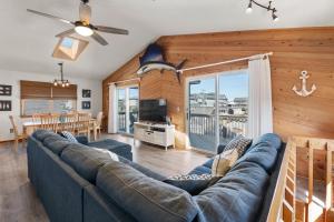 a living room with a blue couch and a dining room at Y-Worry in Kill Devil Hills