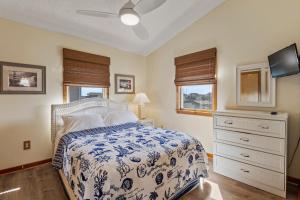 a bedroom with a bed with a blue and white bedspread at Y-Worry in Kill Devil Hills