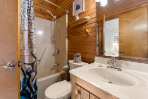 a bathroom with a sink and a toilet and a mirror at Y-Worry in Kill Devil Hills +24 photos