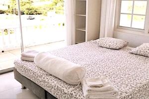 a bed in a room with a large window at Group Accommodation Jan Thiel Curaçao in Willemstad