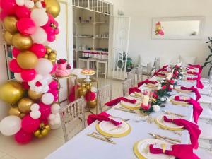 a long table with pink and gold balloons and balloons at Group Accommodation Jan Thiel Curaçao in Willemstad