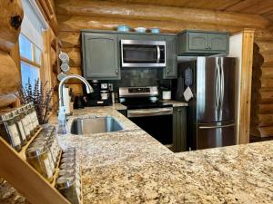 une cuisine avec un réfrigérateur en acier inoxydable et un évier dans l'établissement Peppermint Falls Ranch, à Ponderosa