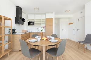 a kitchen and dining room with a wooden table and chairs at Dorsza Green View Pogórze by Solarento in Pogórze