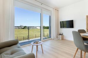 a living room with a couch and a table and a large window at Dorsza Green View Pogórze by Solarento in Pogórze +37 photos
